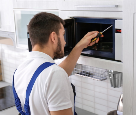 Microwave repair services, the master repairs the microwave